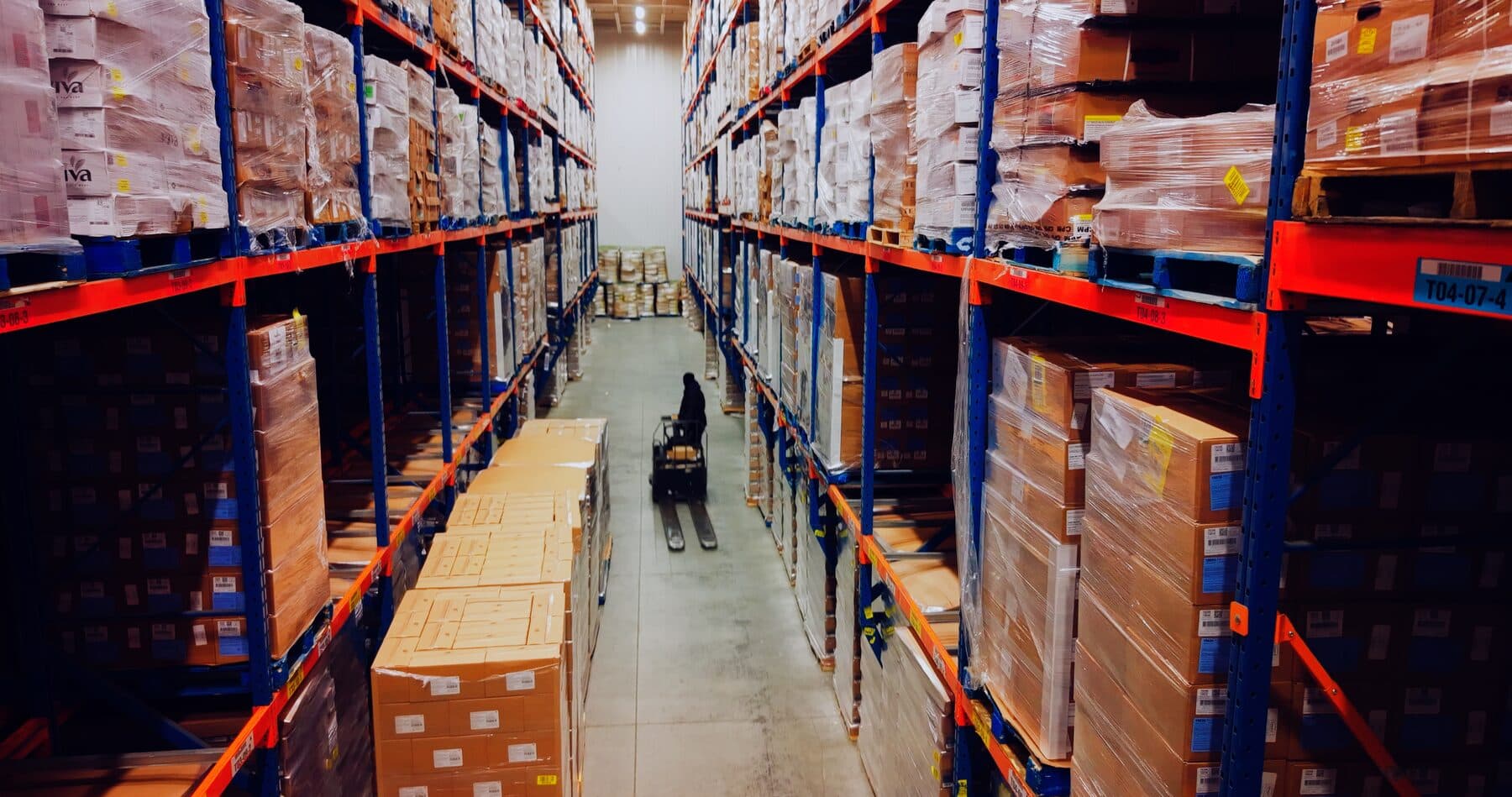 High-density refrigerated racking aisle stacked with palletized product